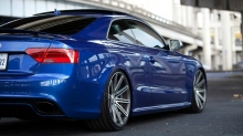 Взгляд сзади на синий Audi RS5 под опорами моста